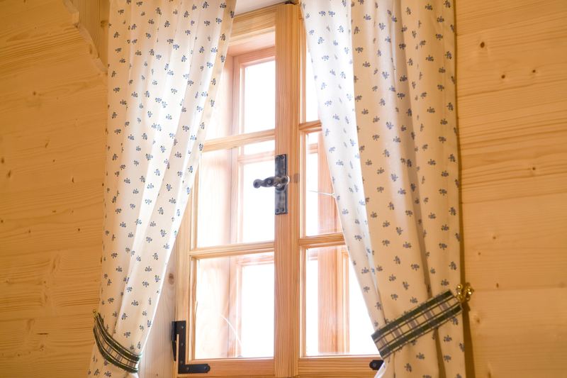 Holzfenster mit Vorhängen im Landhausstil