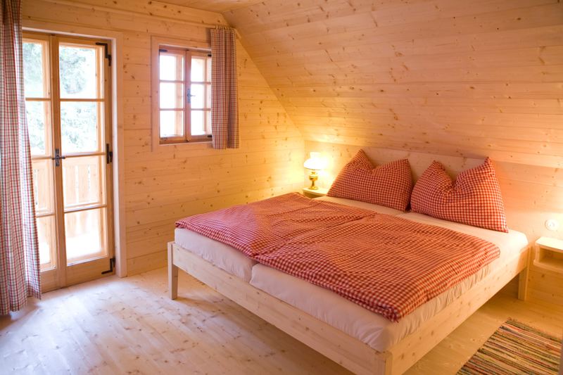 Schlafzimmer mit Doppelbett und Balkontür unter der Dachschräge