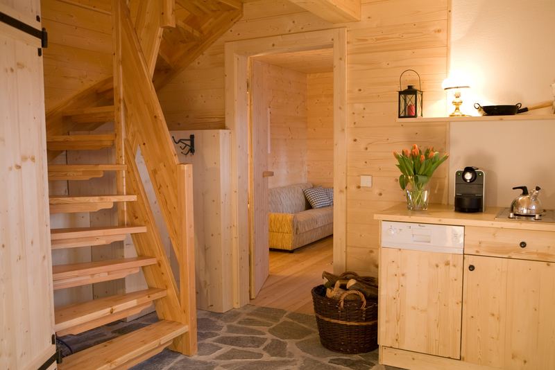 Holztreppe ins Obergeschoss, daneben die Kochnische