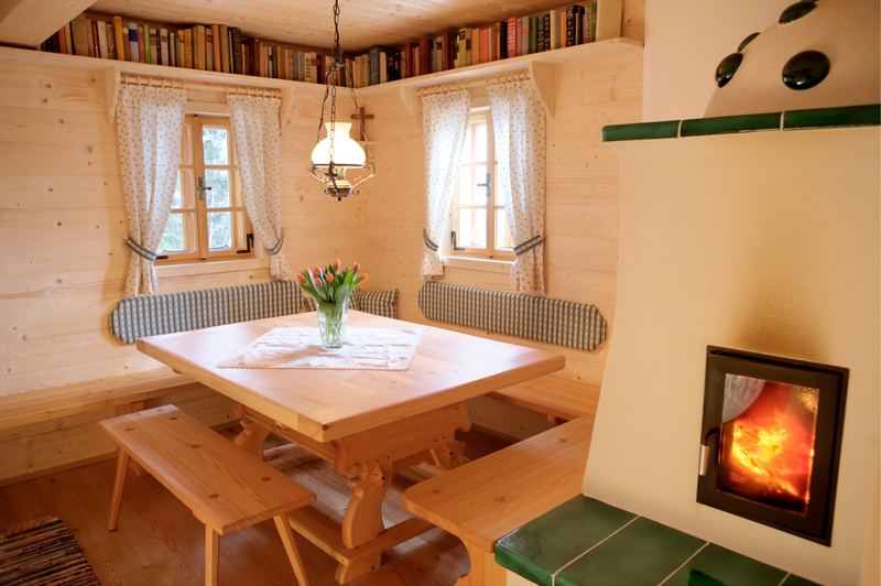 Eckbank mit Tisch, Bücherregal und Kachelofen